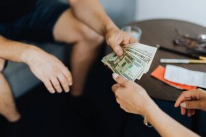person giving money to another person